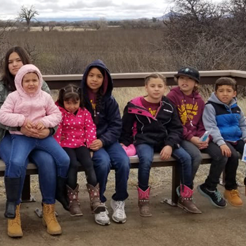 group of students sitting on a bench