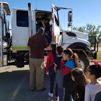 students in line waiting to look at a semi-truck